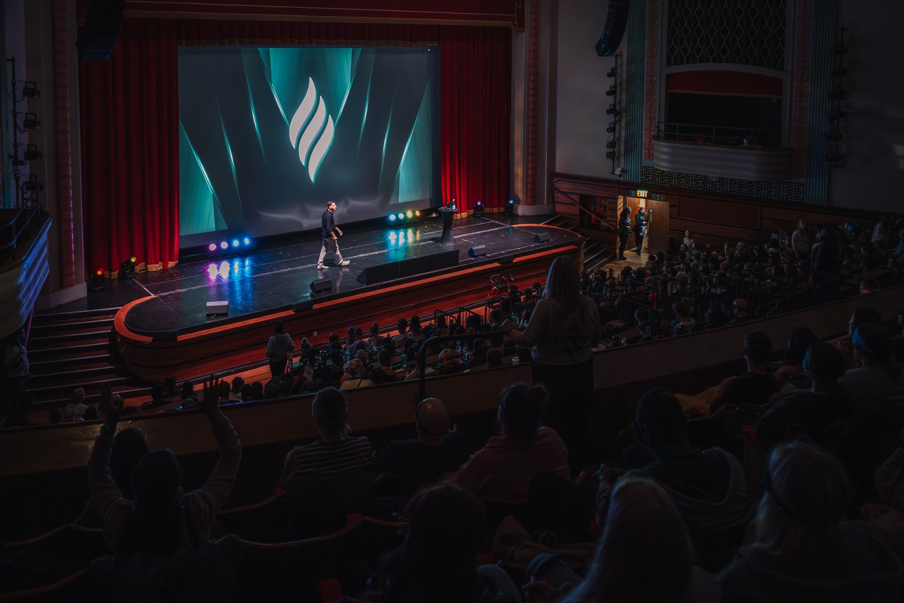 Alexis on stage in front of a packed London theatre